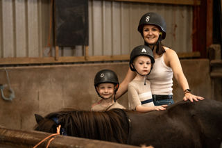 A mum and her two sons posing for a photo with the pony they just pampered.