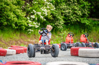 An image of a boy whizzing round the corner of the race track on a pedal go kart at Cantref Adventure Farm.