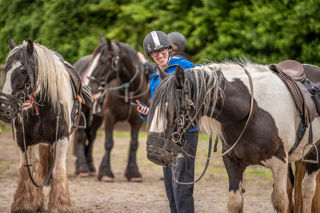 An image of a man thanking the horse for the ride with a big smile on his face.