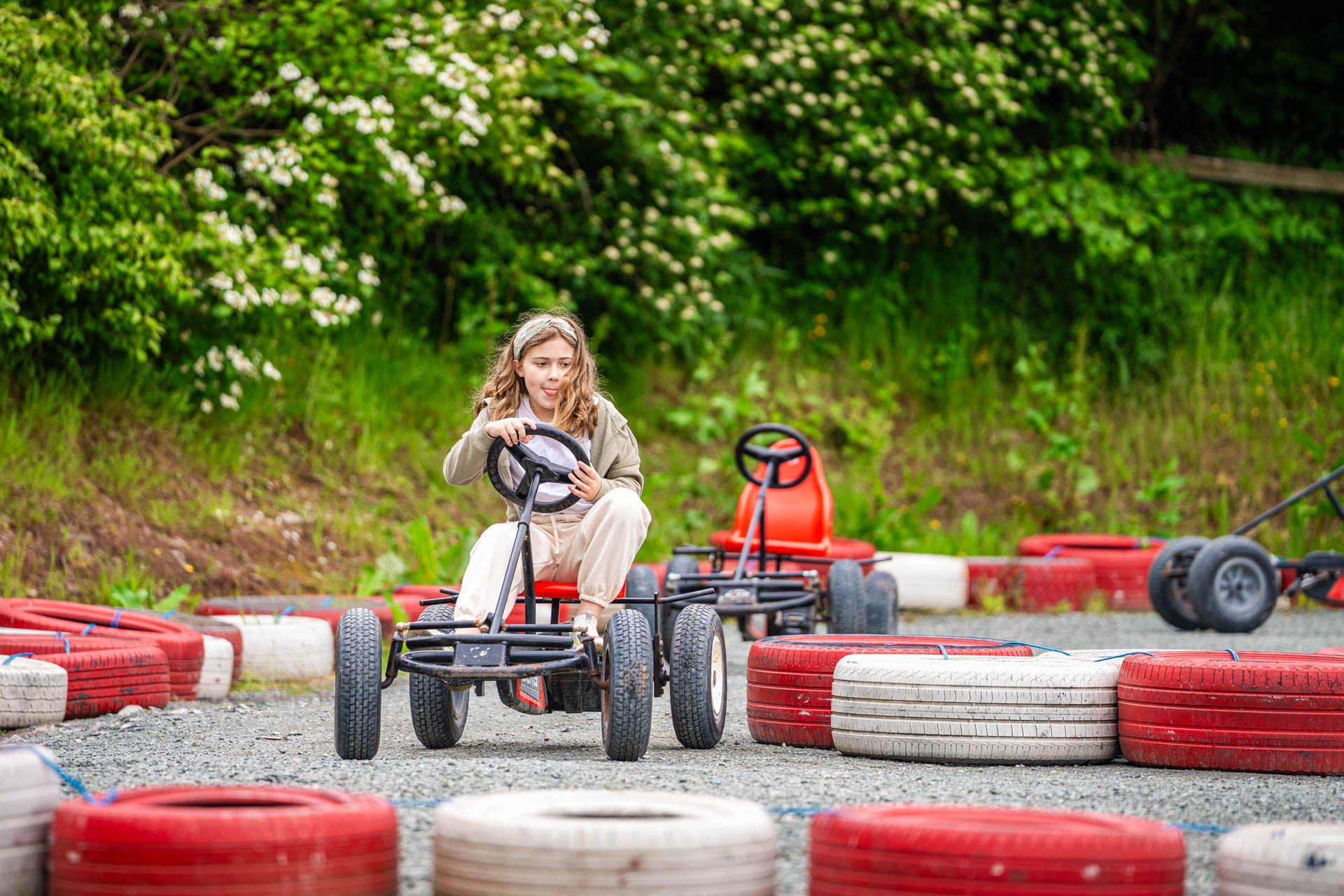 An image of a girl whizzing round the race track on a pedal go kart at Cantref Adventure Farm.