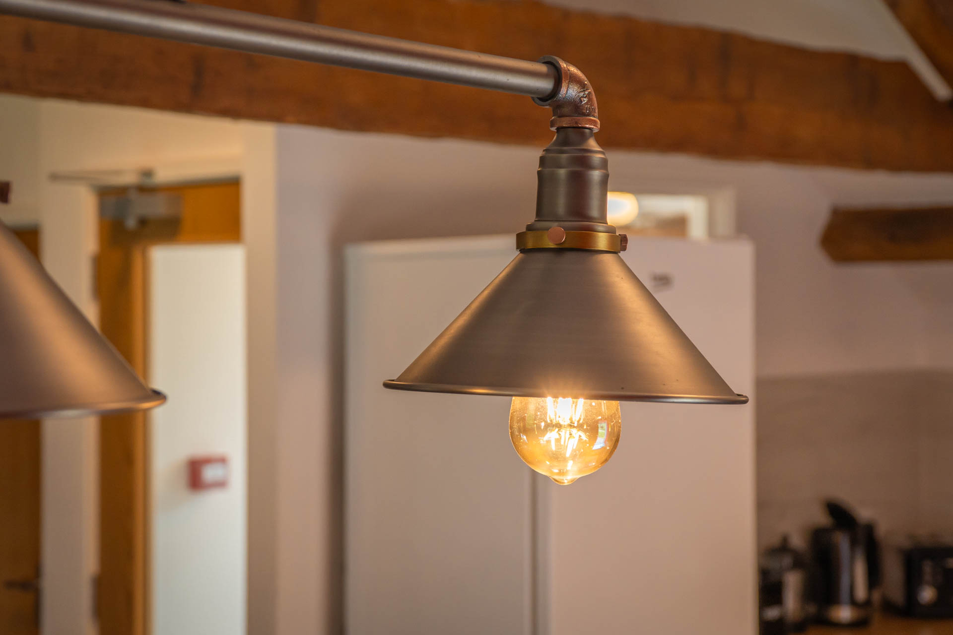 A close up image of an industrial steel light with Eddison bulb.