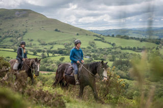 A close up image of a rider on horseback against a backdrop of the stunning Brecon Beacons.
