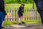 An image of a boy lining up his shot on the crazy golf course.