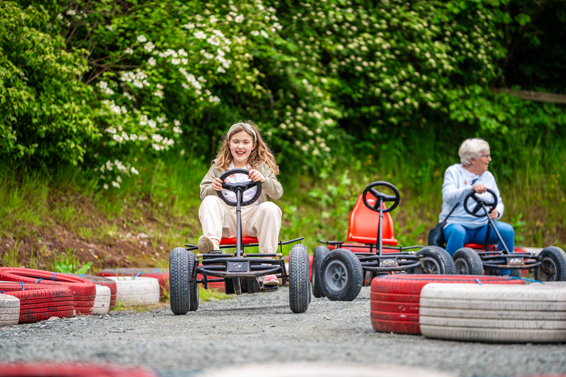 An image of a girl whizzing round the race track on a pedal go kart at Cantref Adventure Farm.