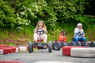 An image of a girl whizzing round the race track on a pedal go kart at Cantref Adventure Farm.