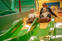 An image of a family going down an indoor slide together at Cantref Adventure Farm.