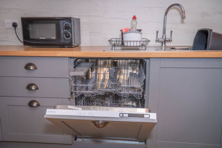 A close up image of the sparkling, integrated dish washer.