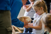 An image of a girl having a guinea pig placed on her lap during a petting session at Cantref Adventure Farm.