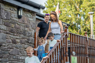 An image of a family of five walking down the stairs from The Grain Store, excited to go into the Farm Park.
